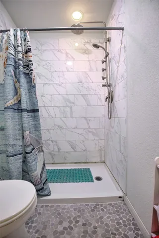 a bathroom with a toilet and a shower
