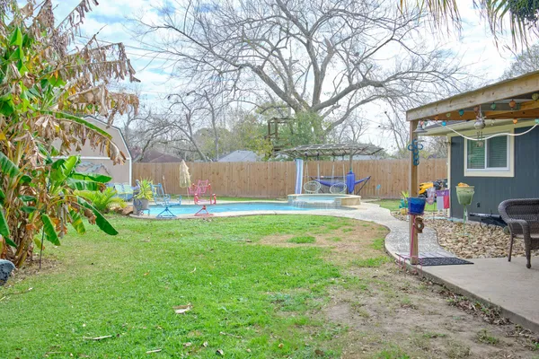 a view of backyard with a table and chairs and potted plants