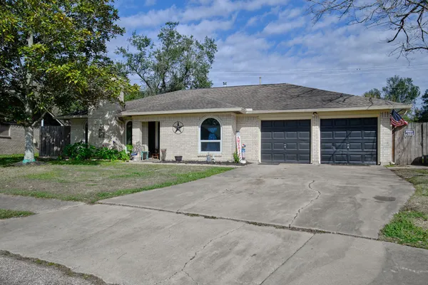 front view of a house with a yard and garage