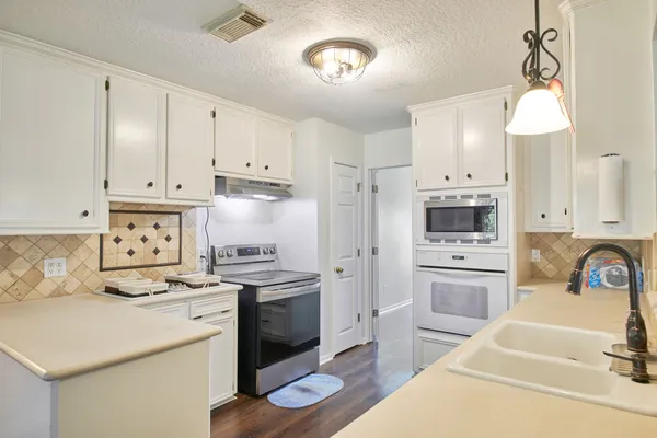 a kitchen with a stove a sink and a refrigerator