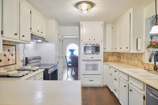 a kitchen with white cabinets and stainless steel appliances