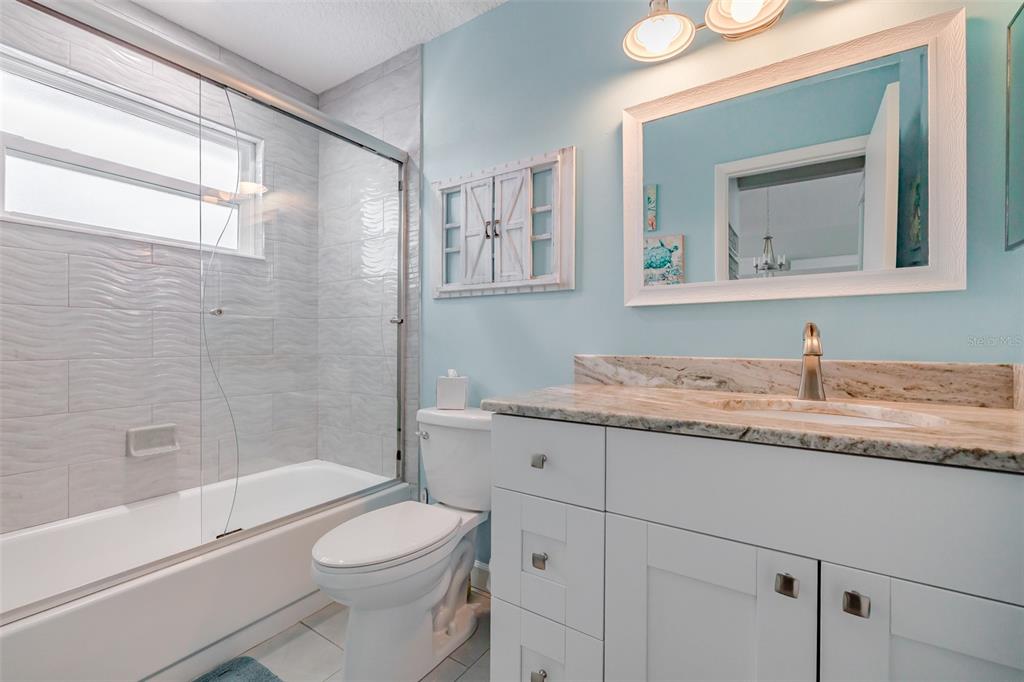 4021 Casa Court Hernando Beach, FL 34607 - Photo 11 of 37 a bathroom with a granite countertop toilet sink and mirror