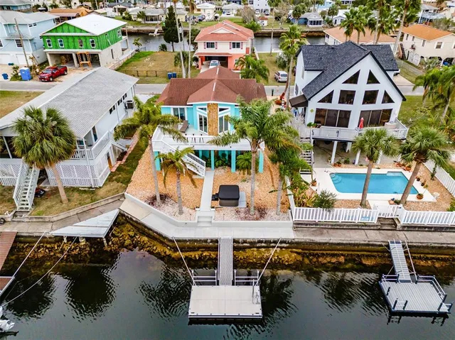 an aerial view of a house with swimming pool and outdoor seating