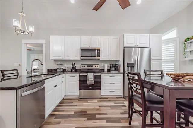 a kitchen with granite countertop a refrigerator stove top oven and sink