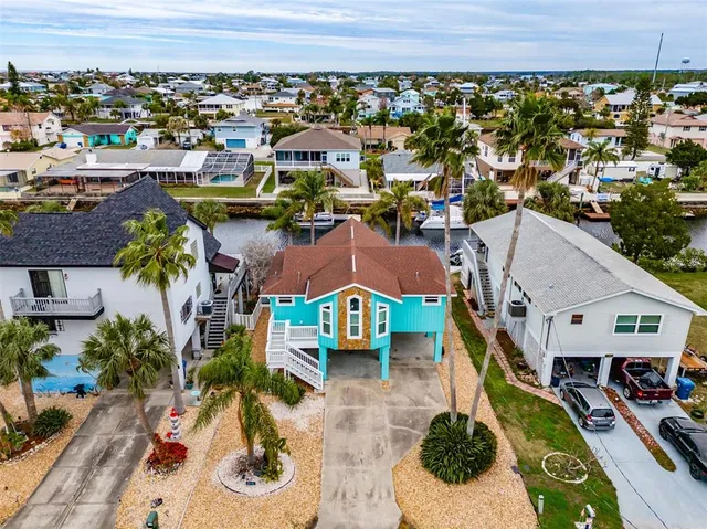 an aerial view of a house with a garden and lake view