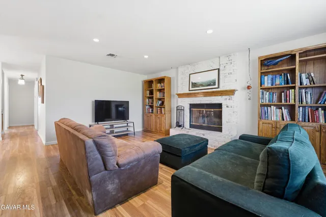 a living room with furniture a flat screen tv and a fireplace