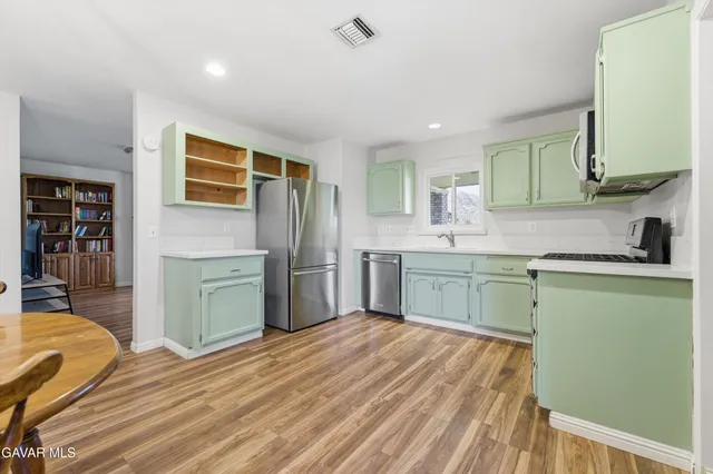 a kitchen with a sink cabinets and wooden floor
