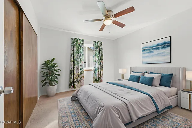 a bedroom with a large bed and a potted plant