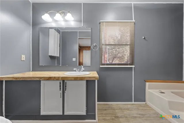 a bathroom with a granite countertop sink a large mirror and a window