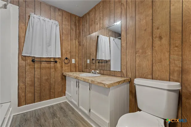 a bathroom with a sink a toilet a mirror and shower curtain
