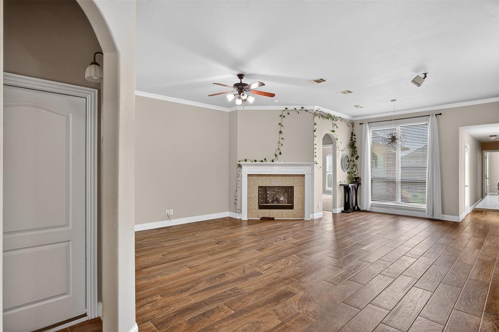 8208 Riversprings Drive Fort Worth, TX 76053 - Photo 23 of 26 an empty room with wooden floor fireplace and windows