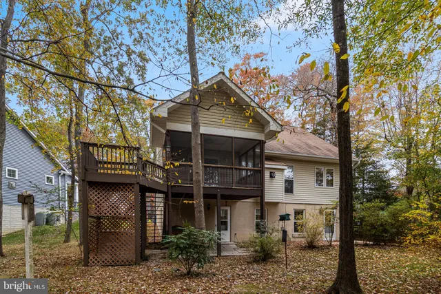 a view of an empty room with wooden floor fireplace and a window