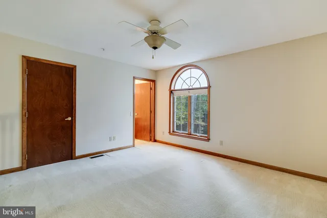 a view of a livingroom with a ceiling fan and entryway