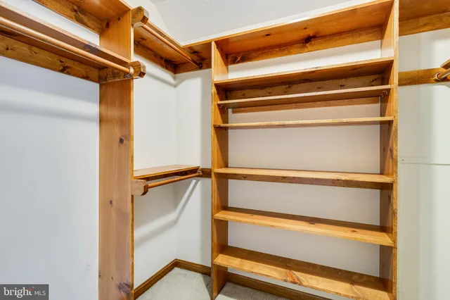 a view of a room with wooden floor closet and windows