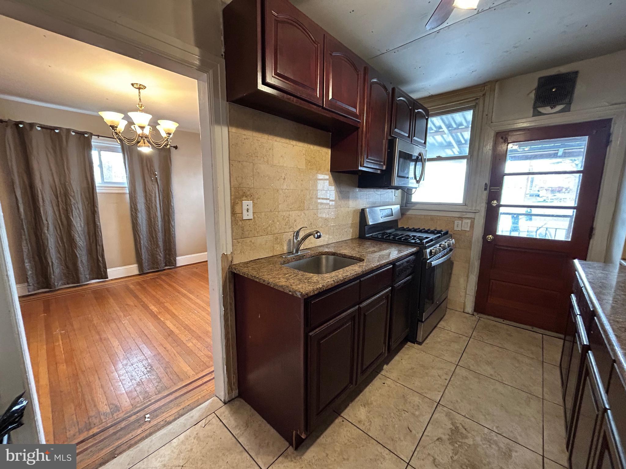 7502 Parkview Road Upper Darby, PA 19082 - Photo 15 of 63 a kitchen with stainless steel appliances granite countertop a stove a sink and a microwave