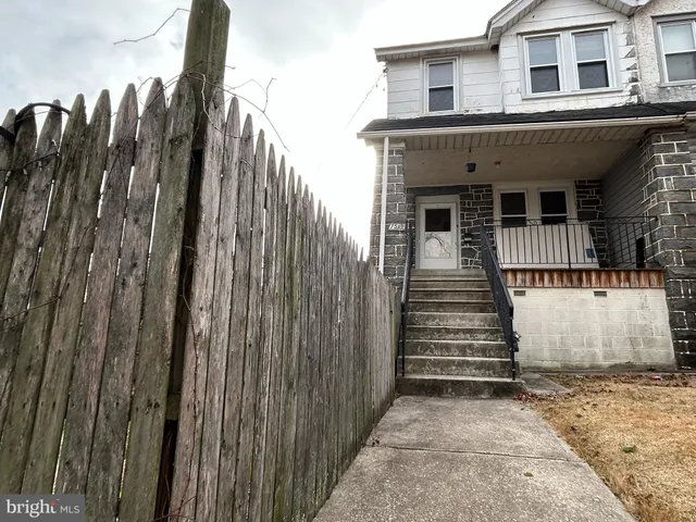 a view of a house with a door and wooden fence