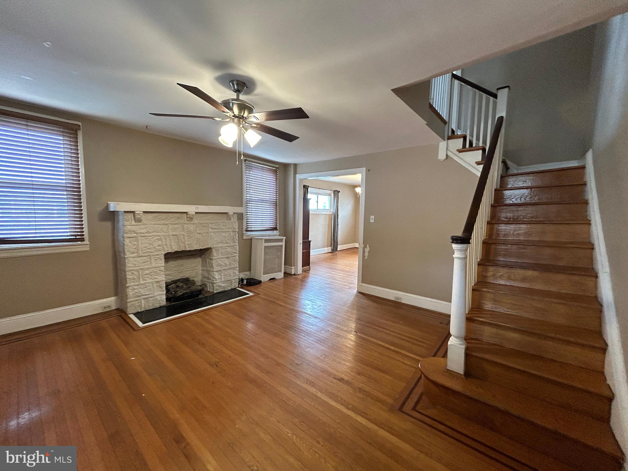 7502 Parkview Road Upper Darby, PA 19082 - Photo 6 of 63 a view of an empty room with wooden floor fireplace and a window