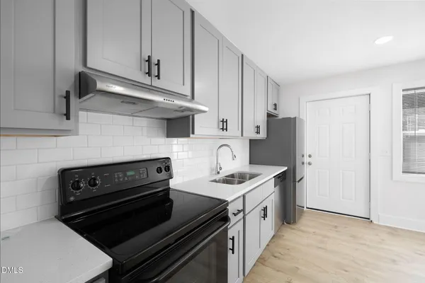 a kitchen with a sink a refrigerator and cabinets