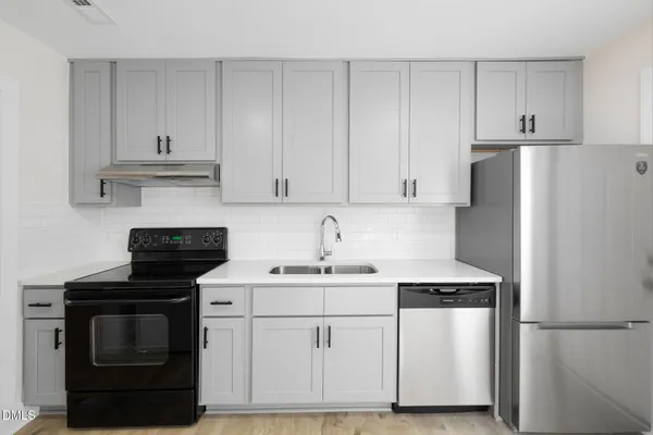 a kitchen with white cabinets and white appliances