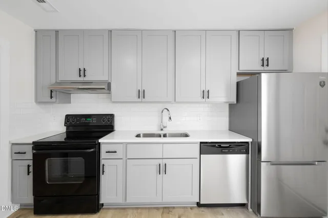 a kitchen with white cabinets and white appliances
