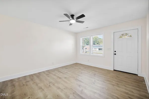 a view of a livingroom with a ceiling fan & wooden floor