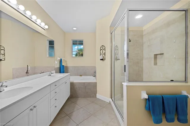a bathroom with a double vanity sink a mirror and a bathtub