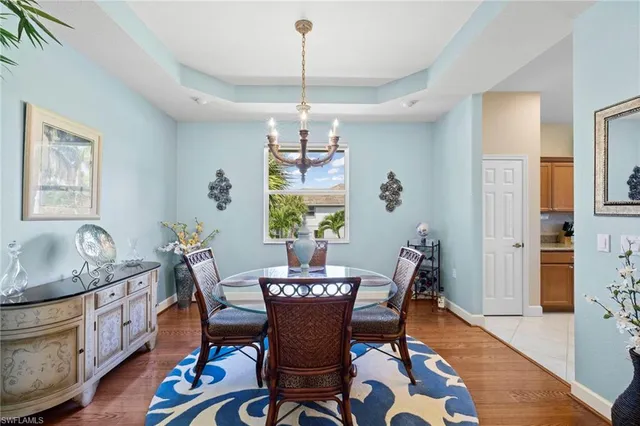 a dining room with furniture a chandelier and wooden floor