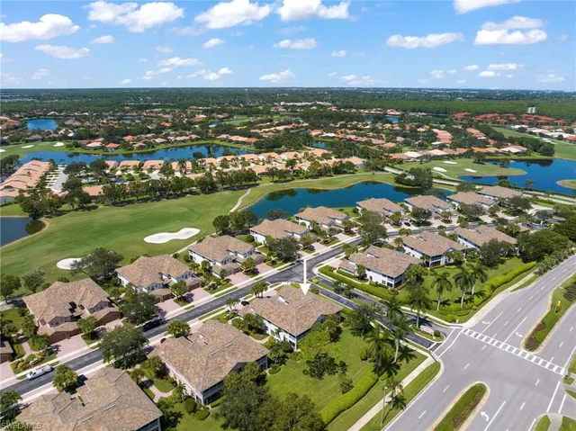 an aerial view of a city with lots of residential buildings and lake view in back