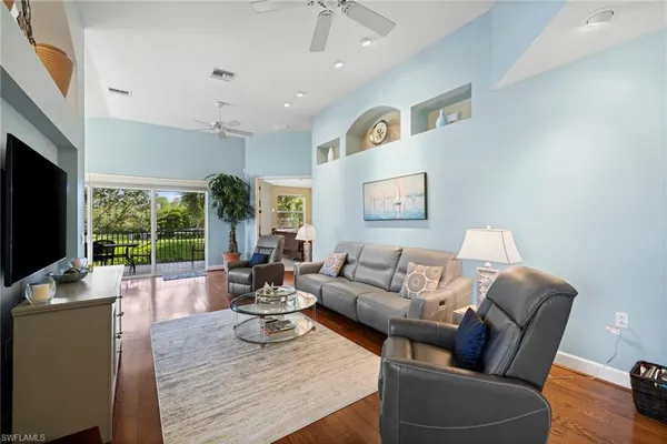 a living room with furniture flat screen tv and a large window