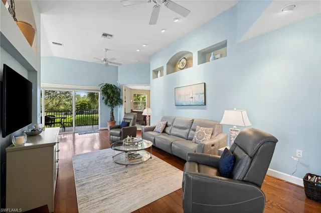 a living room with furniture flat screen tv and a large window
