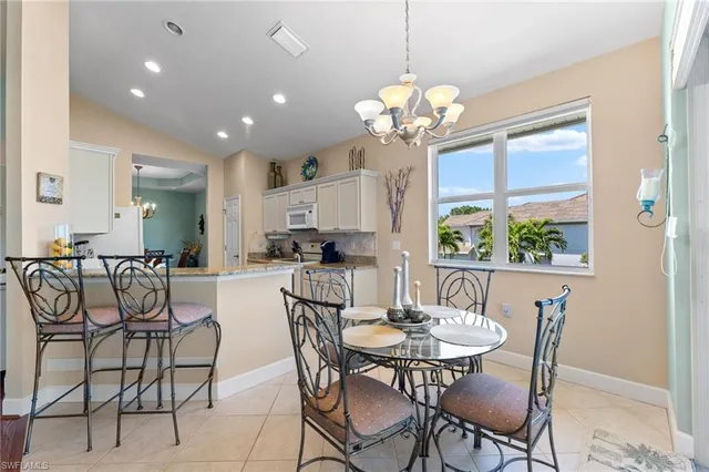 a view of a dining room with furniture a chandelier and wooden floor