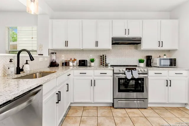 a kitchen with stainless steel appliances granite countertop a sink and a stove