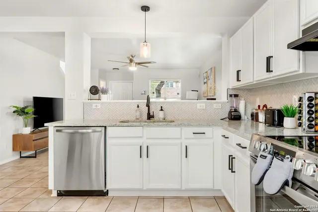 a kitchen with cabinets and chairs