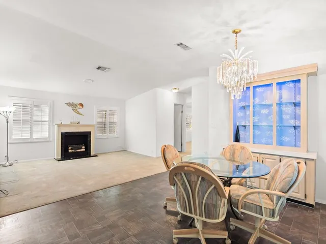 a view of a dining room with furniture a chandelier and wooden floor