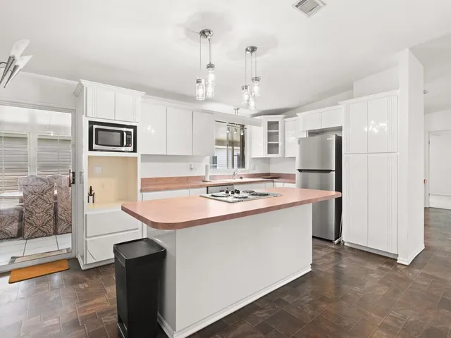 a kitchen with kitchen island a sink appliances and cabinets