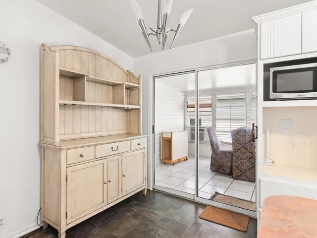 a kitchen with stainless steel appliances a large window and cabinets