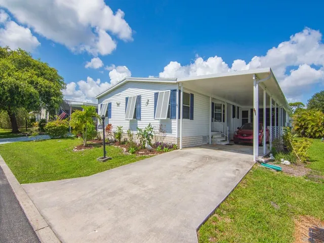 a front view of a house with a yard and potted plants