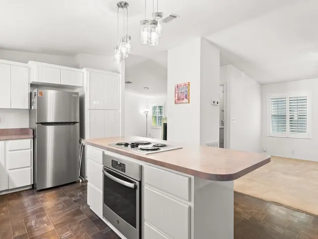 a kitchen with kitchen island a stove a refrigerator and a stove