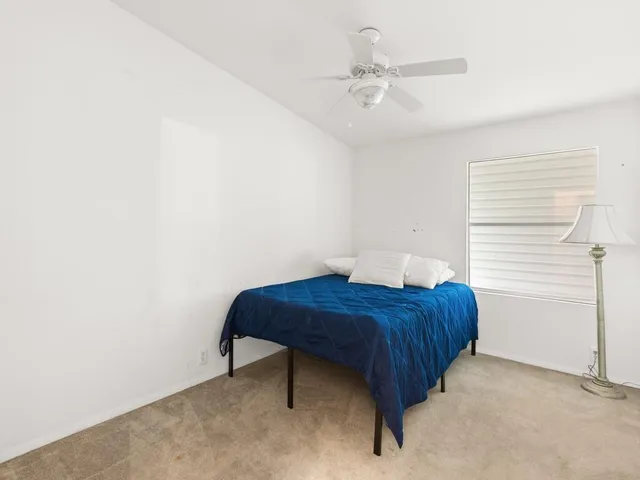 a room with a bed and a ceiling fan