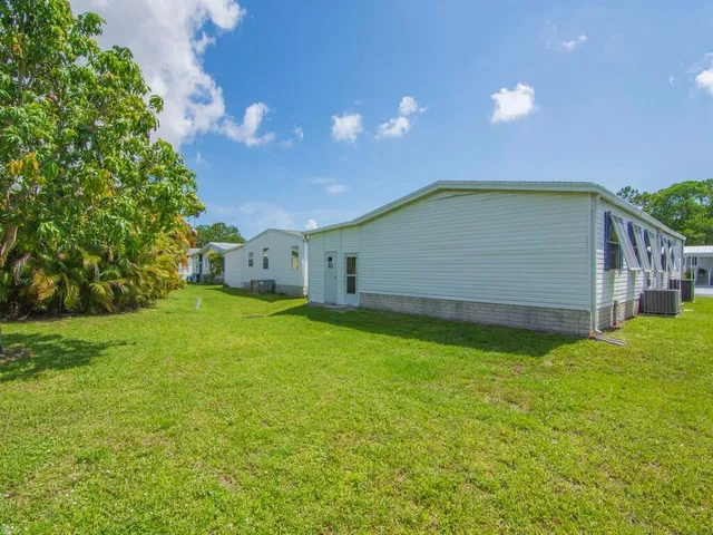 a backyard of a house with plants and large trees