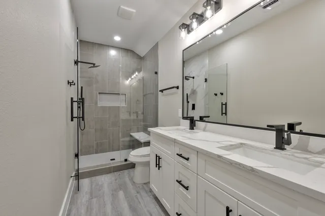 a bathroom with a sink shower and a mirror