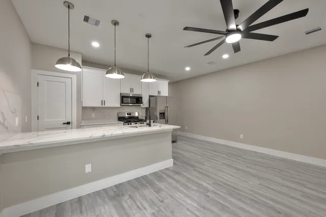 a kitchen with stainless steel appliances a sink stove and refrigerator