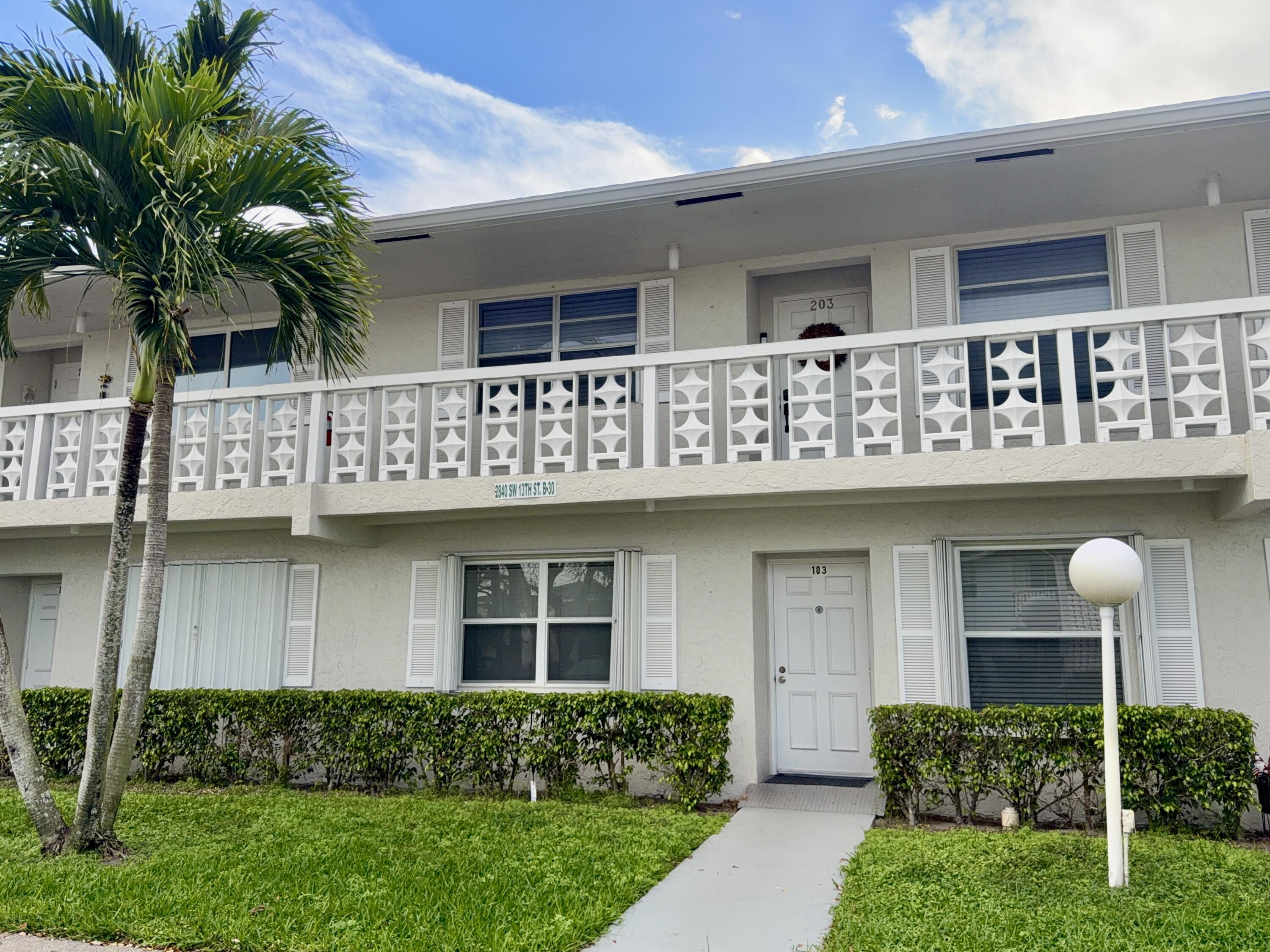 2840 Southwest 13th Street, Unit 103 Delray Beach, FL 33445 - Photo 2 of 72 a view of a house with a small yard and plants