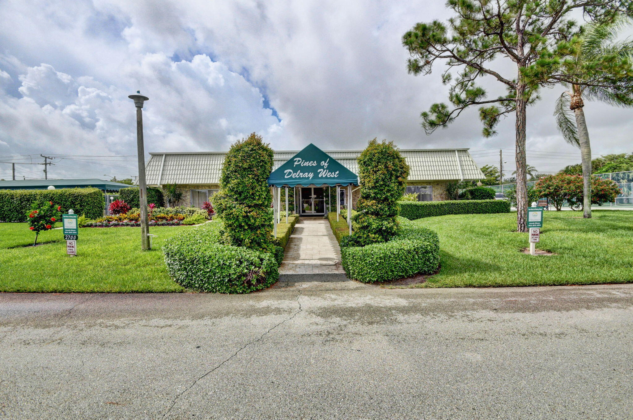 2840 Southwest 13th Street, Unit 103 Delray Beach, FL 33445 - Photo 70 of 72 a front view of a house with a yard and garage