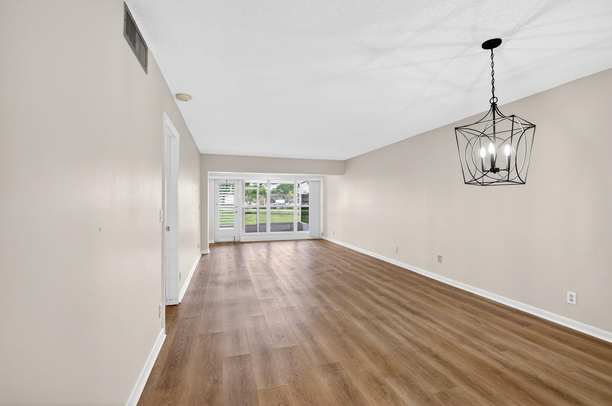 2840 Southwest 13th Street, Unit 103 Delray Beach, FL 33445 - Photo 9 of 72 a view of empty room with wooden floor and fan