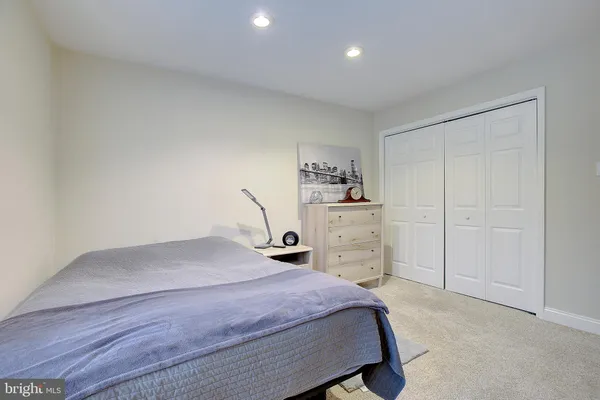 a bedroom with a bed book shelf and a window