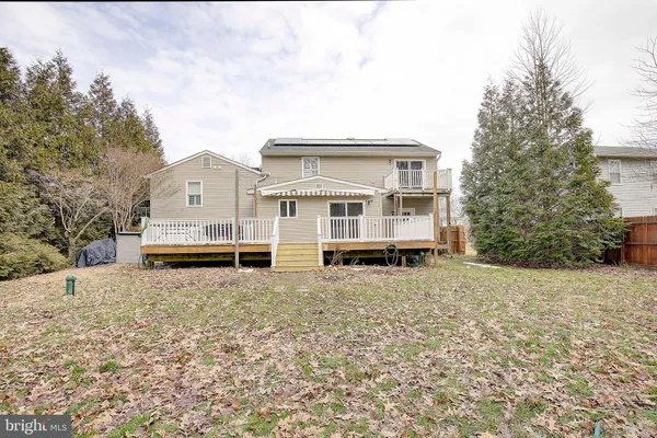 a view of a large white house with a yard covered in snow