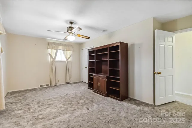 an empty room with closet and windows