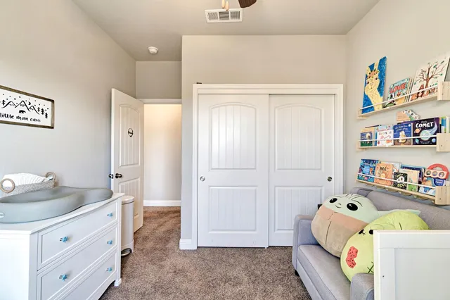a room with a baby bed couch and dresser