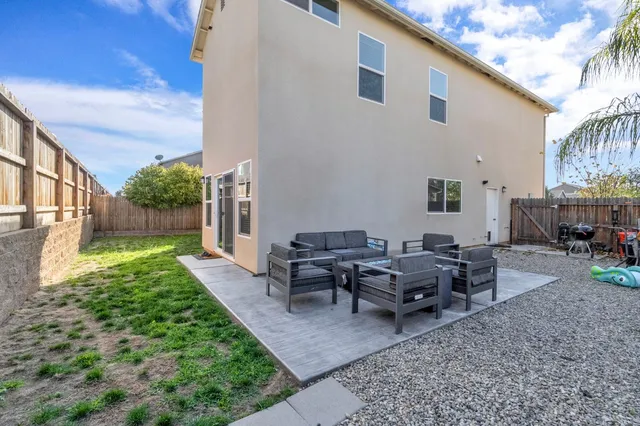 a view of a house with backyard sitting area and garden